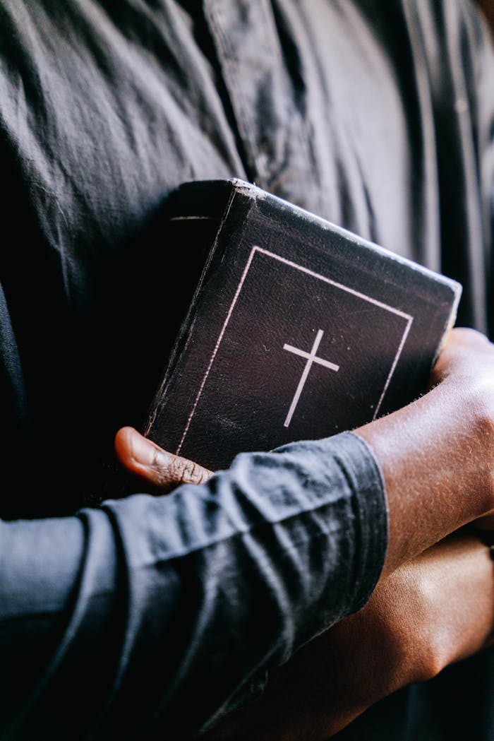 services-img Close-up of a person holding a holy bible with a cross, focusing on religion and faith.